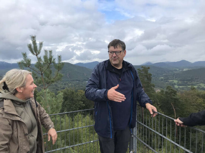 Auf dem Hühnerfelsen hoch über Schwanheim erläuterte Ortsbürgermeister Herbert Schwarzmüller, der mit Bürgermeister Patrick Weißler die Tour geführt hatte, Landrätin Dr. Susanne Ganster den atemberaubenden Ausblick über den Pfälzerwald. (Foto: Kreisverwaltung Südwestpfalz)