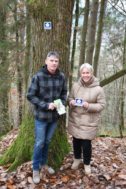 Die Markierung am Baum hat Udo Bölts wie alle anderen auf der Verbindungsroute des Jakobsweges angebracht, dessen Logo und Kennzeichnung Landrätin Dr. Susanne Ganster bei der Eröffnung des Weges in Händen hielt. (Foto: Kreisverwaltung Südwestpfalz)