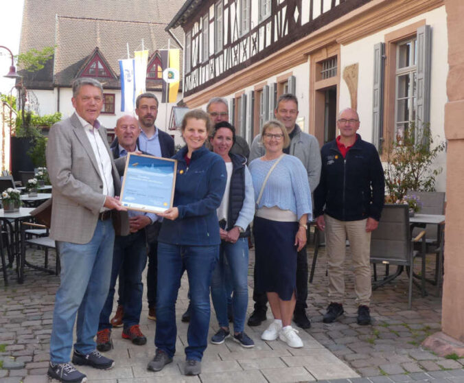 Karl Schäfer, Ortsbürgermeister (links) und Dr. Friedericke Weber, mit dem Zertifikat. Mit dabei waren Mitglieder des Gemeinderats und Vertreterinnen und Vertreter aus dem Bereich Tourismus (Foto: UNESCO Biosphärenreservat Pfälzerwald-Nordvogesen)
