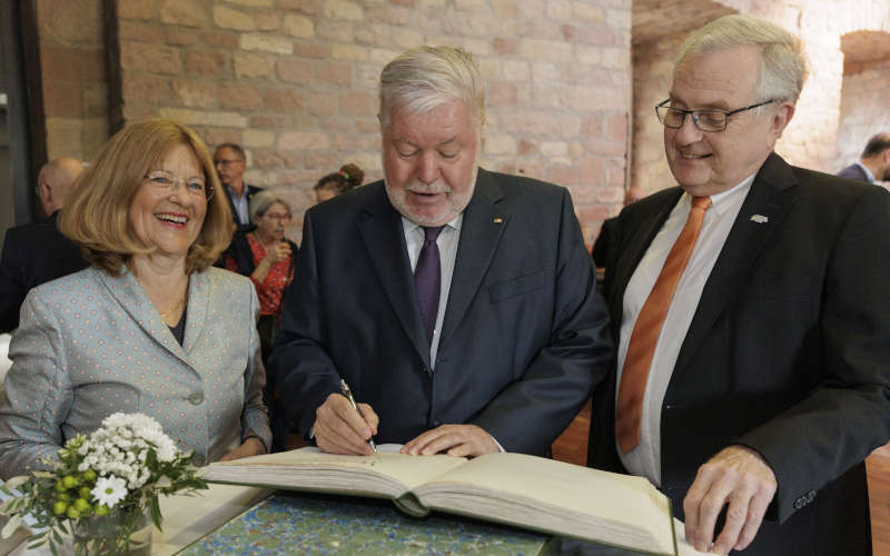 Eintrag ins Gästebuch des Bezirksverbands Pfalz (von links): Laudatorin Theresia Riedmaier, Kurt Beck und Bezirkstagsvorsitzender Theo Wieder (Foto: Reiner Voß / view)