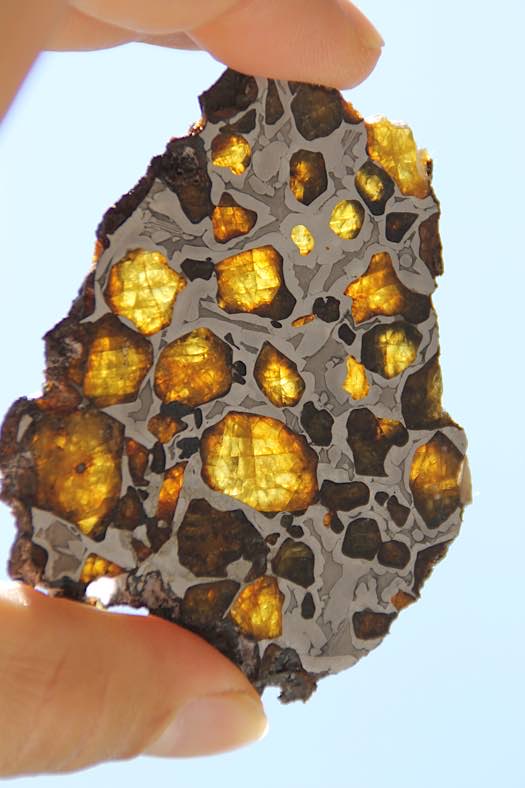 Pallasite (Meteorit aus Sibirien) bestehen aus Olivinkristallen, in einer Matrix aus Nickel-Eisen (Quelle: MMS – Mineralientage Mark Schneider)