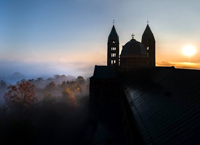 Der Dom vor der aufgehenden Sonne – das Titelmotiv der diesjährigen Internationalen Musiktage zum Thema „Glaube“ (Quelle: Domkapitel Speyer, Foto: Klaus Landry)