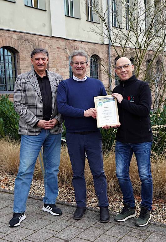 Auf dem „Teufelspfad“ wird weiterhin auf Premium-Niveau gewandert. Darüber freuen sich Manuel Andrack (Mitte) vom Deutschen Wanderinstitut, der die Urkunde an Stadtmarketing-Chef Rolf Schlicher (links) und Mitarbeiter Götz Krämer übergeben hat, der für das Thema Wandern zuständig ist. (Foto: Stadtverwaltung Pirmasens / Sabine Reiser)