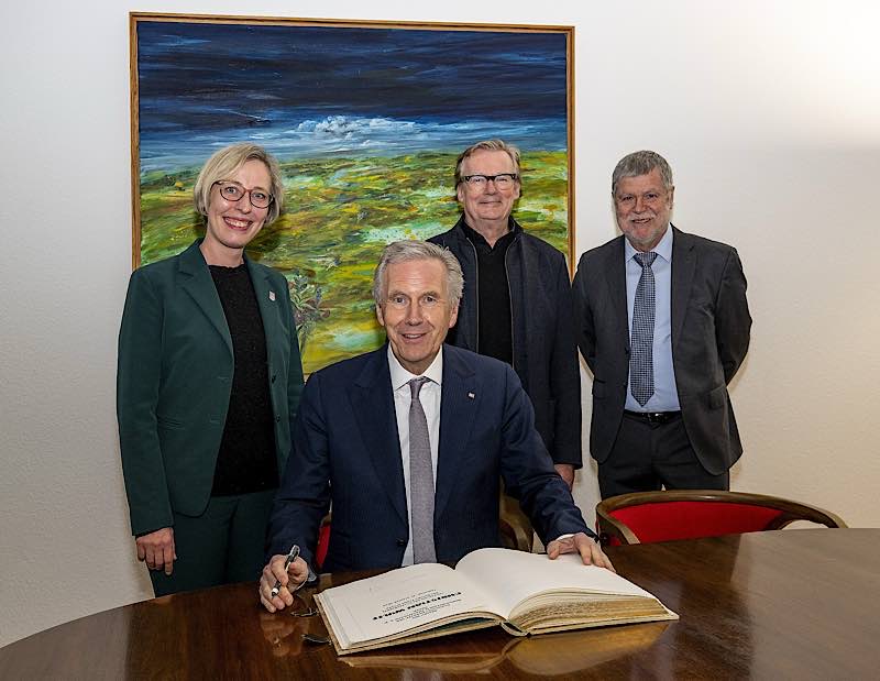 Christian Wulff trägt sich in das Goldene Buch der Stadt Speyer ein. Von links: Stefanie Seiler, Oberbürgermeisterin der Stadt Speyer; Bundespräsident a.D. Christian Wulff (sitzend), Stefan Detzel, Präsident Rotary Club Speyer; Thomas Grebner, verantwortlicher Organisator des Galakonzerts. (Foto: Klaus Venus/Rotary Club Speyer)