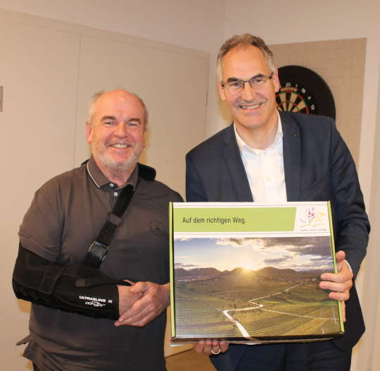 Peter Laux, neues Ehrenmitglied des Madenburgvereins (links), erhielt eine SÜW-Box von Landrat Dietmar Seefeldt. (Foto: KV SÜW)