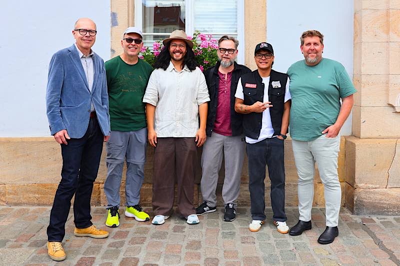 Freuen sich auf die Fête de la Musique in der Landauer Innenstadt: Oberbürgermeister Dominik Geißler (l.), Matthias Müller (2. v. l.), Jeffrey Deubler (3. v. l.) und Yods Pegoro (2. v. r.) von den Fuzo Groovers, die bei der Fête de la Musique auftreten werden, sowie Michael Fromm (3. v. r.) und Armin Schowalter (r.) von der Kulturinitiative Landau. (Quelle: Stadt Landau)