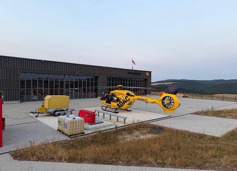 Rettungshubschrauber "Christoph 66" auf dem Vorfeld der neuen ADAC Luftrettungsstation mit Blick auf die umliegende Westpfälzer Landschaft. Bei Bau und Planung wurden lokale Partner, wie Bauunternehmen aus der Region und die örtliche Feuerwehr berücksichtigt. (Foto: ADAC Luftrettung)