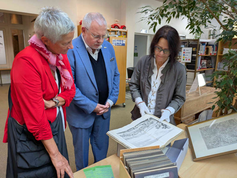 Oberbürgermeisterin Beate Kimmel und Bezirkstagsvorsitzender Hans-Ulrich Ihlenfeld betrachten mit Bibliotheksleitung Claudia Germann einen historischen Stich der Stadt Kaiserslautern. (Foto: Bezirksverband Pfalz)
